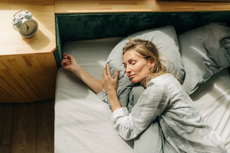 Frau liegt im Bett und findet keine Ruhe